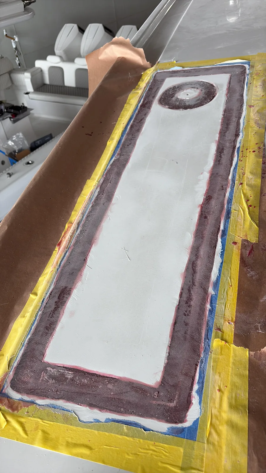 Long hardtop panel masked with yellow tape during surface preparation for refinishing
